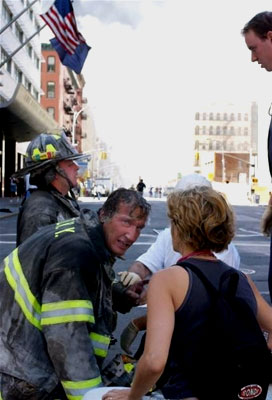 An exhausted hero firefighter receives aid